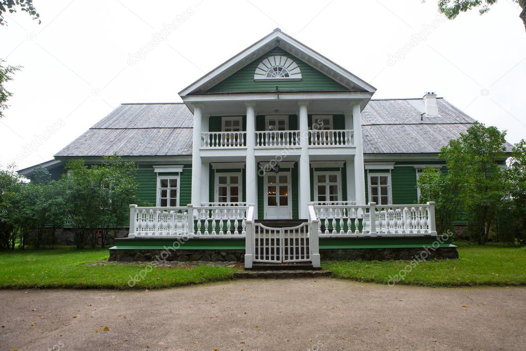 Old wooden house with columns in the park