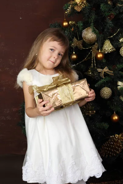 Noel Ağacı Yakınındaki Beyaz Elbiseli Bir Kız Bir Hediye Tutar — Stok fotoğraf