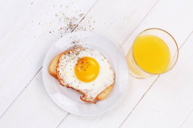 Beyaz ekmek ve bir bardak portakal suyu bir dilim kızarmış yumurta
