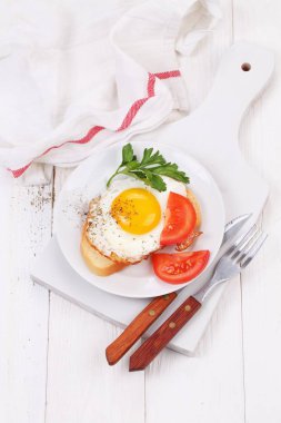 kızarmış yumurta beyaz ekmek ve beyaz ahşap bir masa üzerinde taze domates