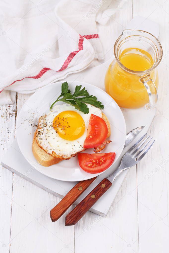 Fried eggs on a slice of white bread with orange juice