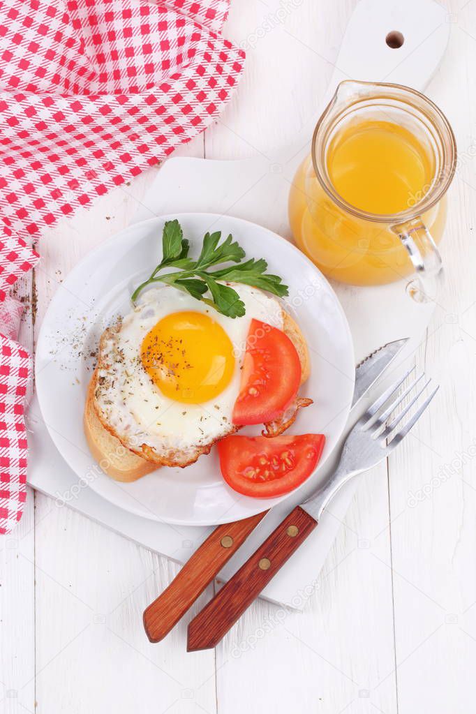 Fried eggs on a slice of white bread with orange juice