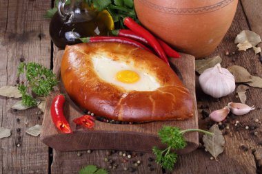 Acara Khachapuri, kişniş, biber ve sarımsak ahşap bir masa üzerinde peynir pasta