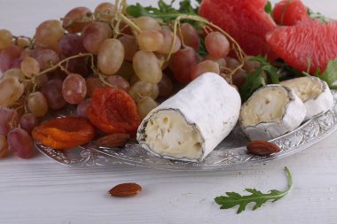 Peynir Saint-Mor-de-Touren meyve ve beyaz arka plan üzerinde roka ile