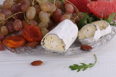 Peynir Saint-Mor-de-Touren meyve ve beyaz arka plan üzerinde roka ile