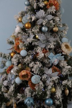 Tinsel ve topları ile süslenen Noel köknar ağacı