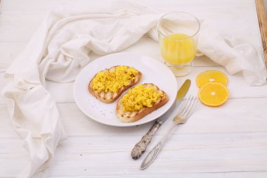 Kızarmış yumurta tost ve portakal suyu ahşap bir masada