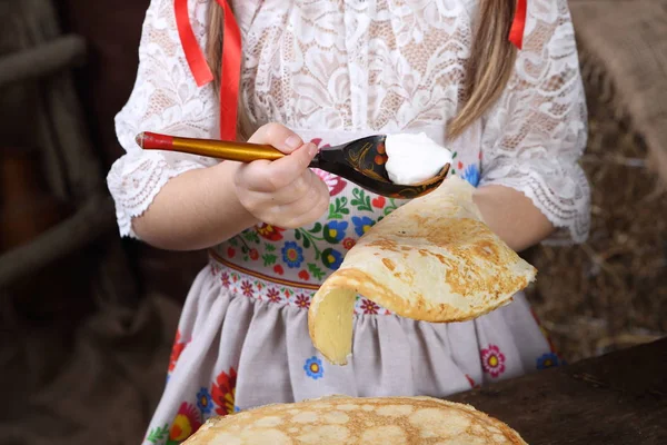 女孩涂抹酸奶在煎饼 — 图库照片