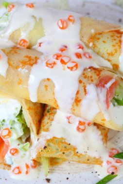 Kırmızı havyar ile beyaz soslu somon ve salata ile Krep