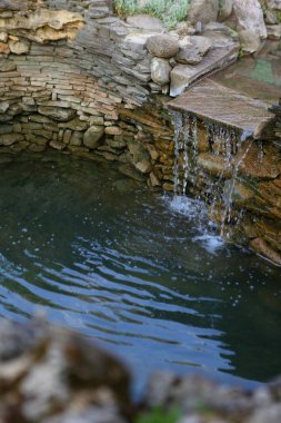 Yapay şelale ile bir gölet dekoratif tasarım.