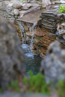 Yapay şelale ile bir gölet dekoratif tasarım.