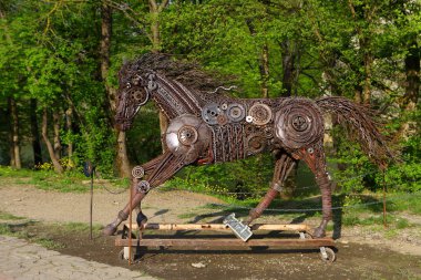 Parkta demirden yapılmış koşan bir at heykeli
