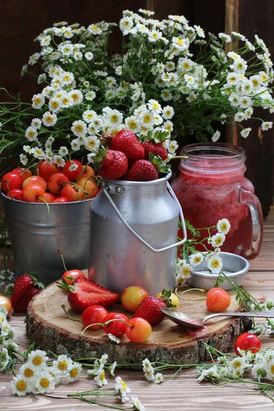 Fresh sweet cherry and strawberries and a bouquet of daisies
