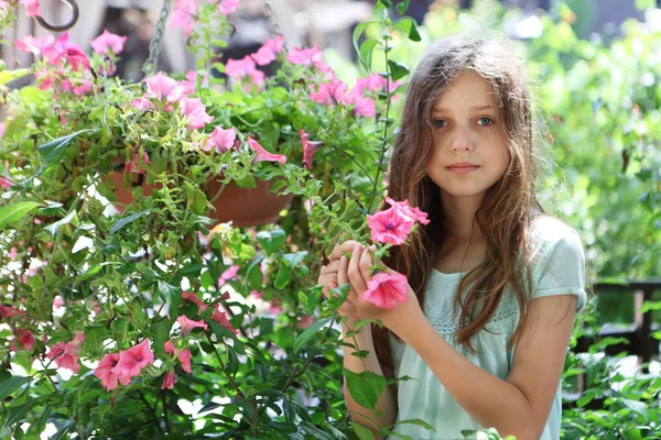 Hermosa Niña Cerca Macizo Flores Con Petunias Rosadas —  Fotos de Stock