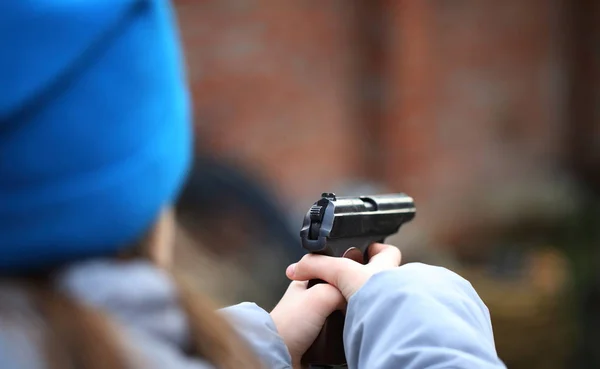 Girl shoots a pistol at a plastic target
