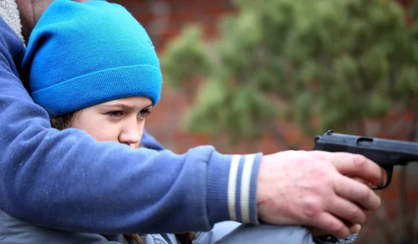 Girl shoots a pistol at a plastic target