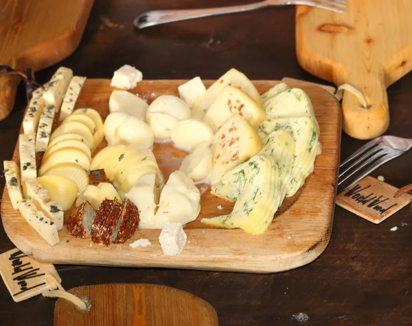 Çeşitli peynir yiyen bir kadın. Peynir dilimleme