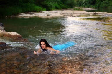 Mavi bir kıyafetle nehirde Denizkızı