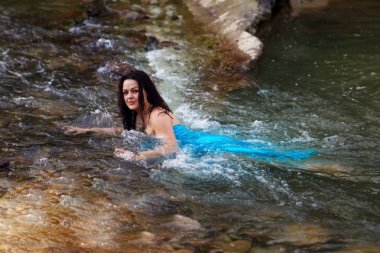 Mavi bir kıyafetle nehirde Denizkızı