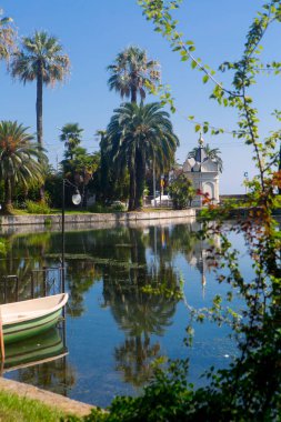 Parkta zakkum ve palmiye ağaçları olan göl