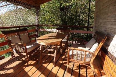 Açık verandada hasır sandalyeler ve ahşap masa