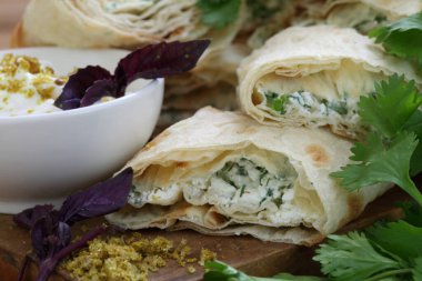 Peynirli rulo ve soslu pide soslu otlar.