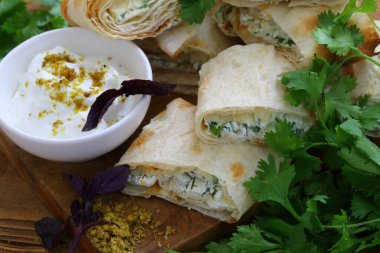 Peynirli rulo ve soslu pide soslu otlar.