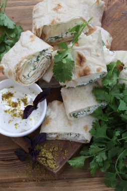 Peynirli rulo ve soslu pide soslu otlar.