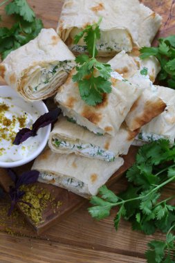 Peynirli rulo ve soslu pide soslu otlar.