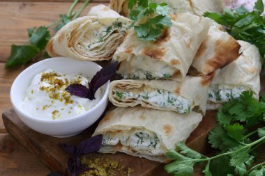 Peynirli rulo ve soslu pide soslu otlar.