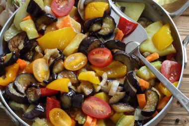 Ahşap arka planda patlıcan ve kabaklı sebze güveci.