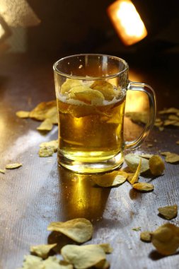 Ahşap arka planda patates kızartması olan bira.