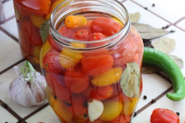 Cam kavanozlardaki domatesler tuzlu suda.