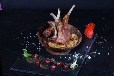 Kuskus kaplı kuzu askısı ve koyu arkaplanda sos.