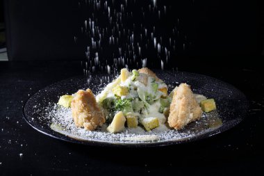 Sezar salatası rendelenmiş peynir serpilmiş.