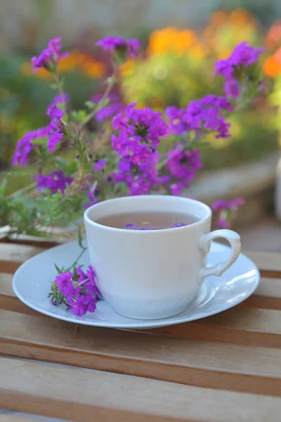 Beyaz Fincanda Çay Terastaki Ahşap Masada Çiçekler — Stok fotoğraf