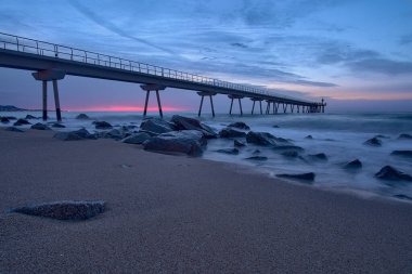 Barcelona, Badalona 'daki Petroleo köprüsünün kumsalından gün doğumu.