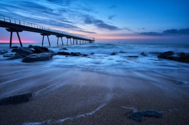 Barcelona, Badalona 'daki Petroleo köprüsünün kumsalından gün doğumu.