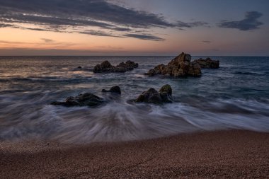 Sant Pol de Mar sahilinde turuncu renklerle gün doğumu (Barcelona)