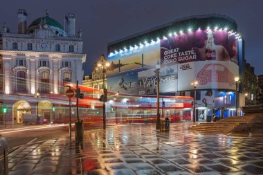 Piccadilly Circus, London-September 8,2017: Light trails from London bus on Piccadilly Circus in rainy early morning time on September 8, 2017 in London, United Kingdom clipart