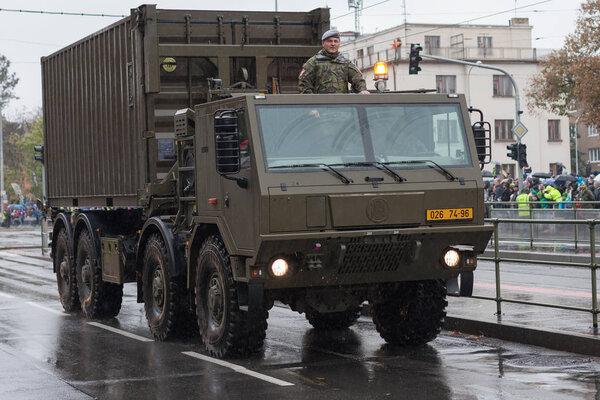 Солдаты чешской армии едут на военном грузовике с контейнером
