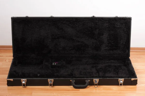 Чорний шкіряний футляр для електрогітари на підлозі в живому — стокове фото