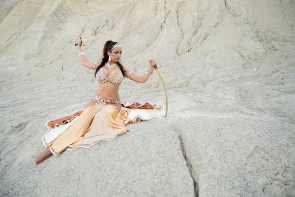 Jovem bela mulher dançarina do ventre posando no deserto com espadas Imagens De Bancos De Imagens Sem Royalties