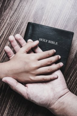 Çocuk ve Adam Eller İncil üzerinde