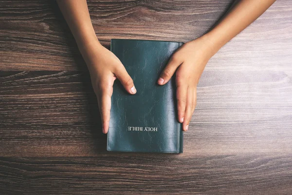 Manos sosteniendo la sagrada Biblia — Foto de Stock