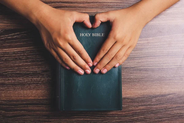 Santa Biblia con las manos en forma de corazón —  Fotos de Stock