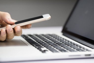 Smartphone ve dizüstü kullanarak iş adamı