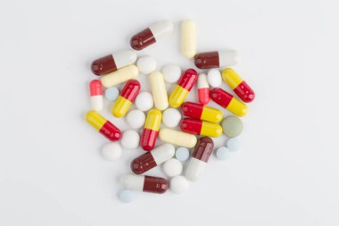 Beyaz arka plan üzerinde ilaç hapları, tabletler ve kapsüller