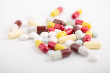 Beyaz arka plan üzerinde ilaç hapları, tabletler ve kapsüller