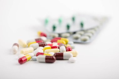 Beyaz arka plan üzerinde ilaç hapları, tabletler ve kapsüller